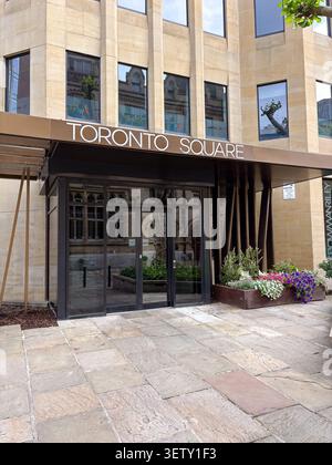 Toronto Square office building facade and entrance. Leeds, UK. Modern stone architecture with glass doors and a floral planter. Stock Photo