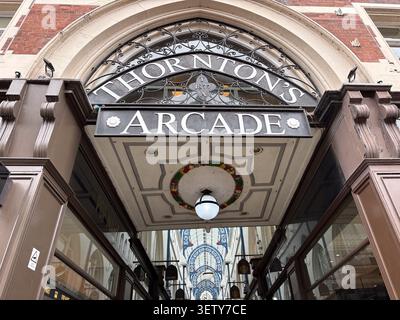 The Victorian entrance to Thorntons Arcade in Leeds, UK, featuring ornate ironwork, stone masonry, and historical architectural detailing. Stock Photo
