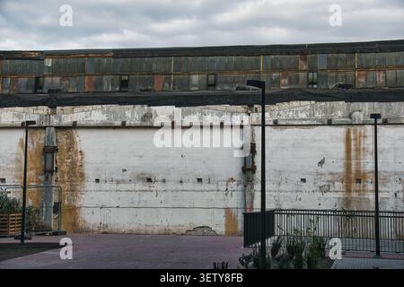 Grungy Industrial Warehouse Wall with Weathered Concrete and Old Windows Stock Photo