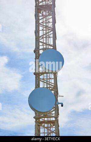 Telecommunication tower with antennas against blue sky. Stock Photo