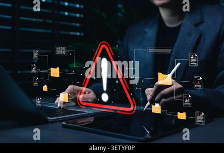 Data breach warning and document risk management concept. Person using laptop with red alert symbol, vulnerable files, suspicious folders cyber threat Stock Photo
