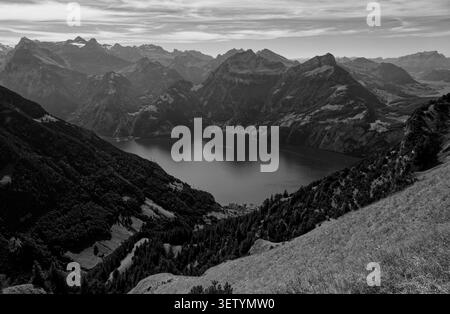 Black & white panorama from the Stoos ridge sweeps across Lake Lucerne’s dark still waters Stock Photo