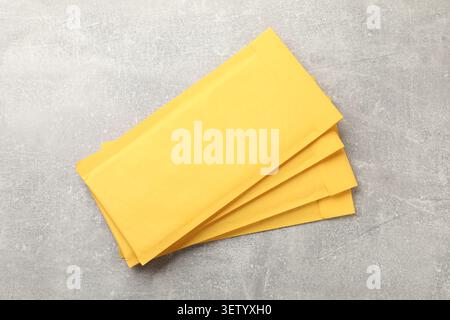 Stack of yellow envelopes on grey table, top view Stock Photo