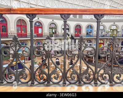 The circular interior of the Leeds Corn Exchange in Leeds, featuring ornate iron railings, boutique shops, and a vaulted glass roof. Stock Photo