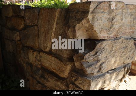 Rustic stone masonry wall constructed from large natural rocks in a historic district, Helena, Montana, USA. Stock Photo