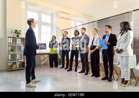 Presenter speaking to diverse office team, group listening during business meeting Stock Photo
