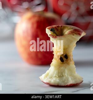A gala apple core with apples in soft focus in behind. Stock Photo
