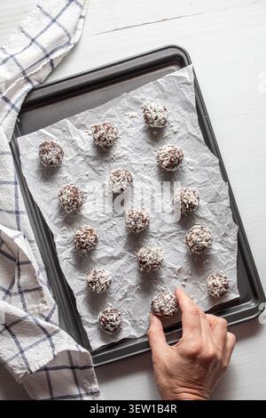 Chocolate coconut covered date energy balls on a baking sheet. Stock Photo