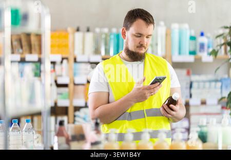 Male builder scans code on cough syrup to check expiration date Stock Photo