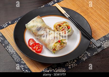 Yunnan style fresh rice sheets wrapped with mixed vegetables on a black square plate Stock Photo