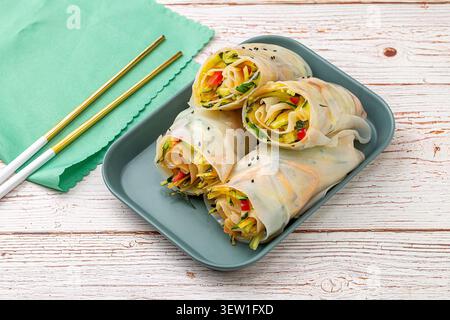 Yunnan style fresh rice sheets wrapped with mixed vegetables on a black square plate Stock Photo
