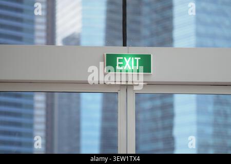 Sign shows exit in a building with glass door Stock Photo
