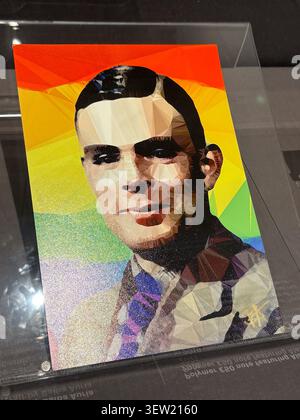 Low-poly artistic portrait of Alan Turing set against a rainbow background, displayed in a Manchester, UK exhibition. Stock Photo