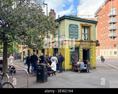 Historic Victorian public house with a bright green tiled facade. Peveril of the Peak, City Centre, Manchester, England. Stock Photo
