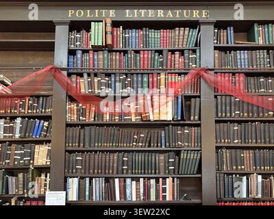 Wooden bookshelves titled Polite Literature filled with antique books at The Portico Library, Manchester, UK. Stock Photo
