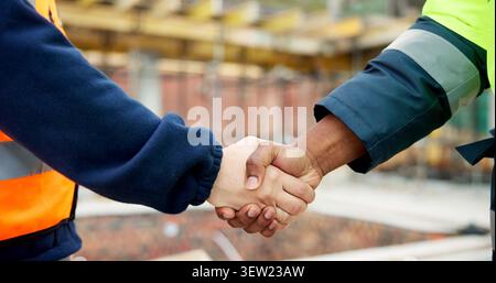 Men, shaking hands or engineers on construction site for agreement, development deal or welcome. Contractor, team or handshake with cooperation for Stock Photo