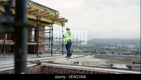 Man, engineer and tablet at site with phone call, discussion and inspection for construction. Space, person and digital on rooftop with mobile Stock Photo