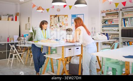 Women collaborating in a creative sewing workshop Stock Photo