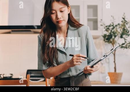Young adult asian business woman using laptop chat digital artificial intelligence assistance ai chatbot prompt analysis work modern lifestyles Stock Photo