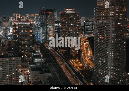 Abstract urban composition of a curved elevated highway and traffic light trails among Tokyo skyscrapers Stock Photo