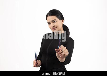 Businesswoman looking at the camera while holding a pen in her hand ready to write Stock Photo