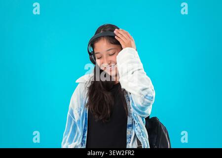 Young woman wearing headphones and looking down with a relaxed expression  Stock Photo