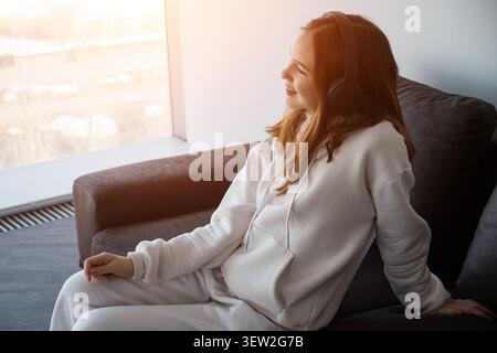 Young woman enjoying music and relaxing at home Stock Photo