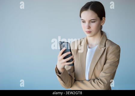 Young woman focusing on smartphone for business communication Stock Photo