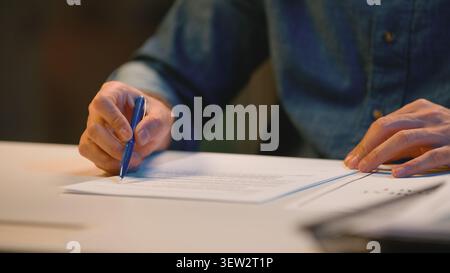 Close up unrecognizable business man writing in papers male hands signing documents at table Cropped view unknown businessman boss leader lawyer write Stock Photo