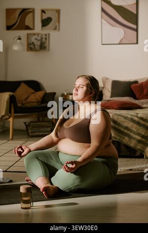 Plus Size Woman Meditating at Home for Body Positivity Wellness Stock Photo