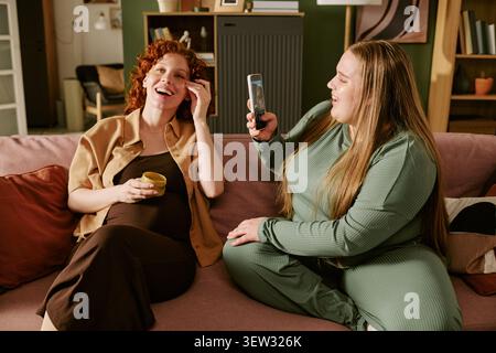 Plus Size Women Video Calling Friend While Relaxing at Home Stock Photo