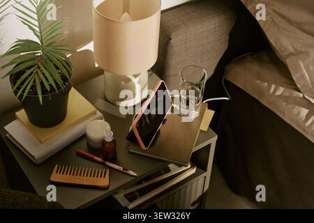 Smartphone Charging on Bedside Table for Evening Wellness Routine Stock Photo