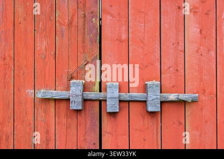 Old lock on a wooden door at a red wooden barn Stock Photo