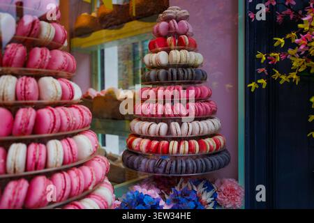 Macaron display in bakery storefront window with pastry towers Stock Photo