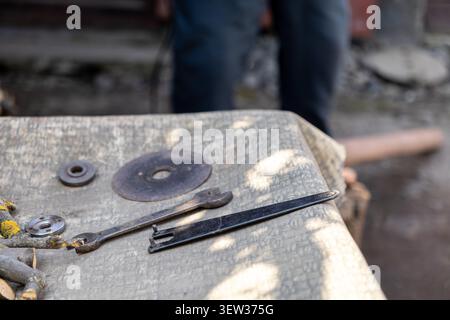 Essential metal cutting disc and pin spanner wrench arranged on a rugged surface, illustrating technical readiness for mechanical tasks, hardware asse Stock Photo