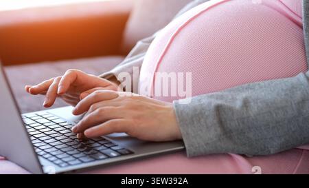 Pregnant woman remote working on laptop at home Stock Photo