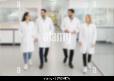Blurred background of a team of scientists in a modern laboratory. Diverse researchers in white coats collaborating on medical research. Stock Photo