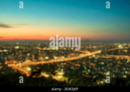 The lights of a night city with circular bokeh blue horizon. Colorful abstract circles of light from street lanterns blurred in the twilight evening. Stock Photo