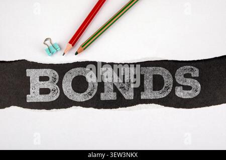 Bonds financial concept shown by word BONDS on torn paper with office supplies Stock Photo