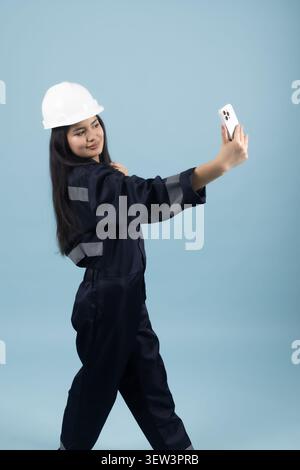 Female industrial construction worker wearing protective white hardhat Stock Photo