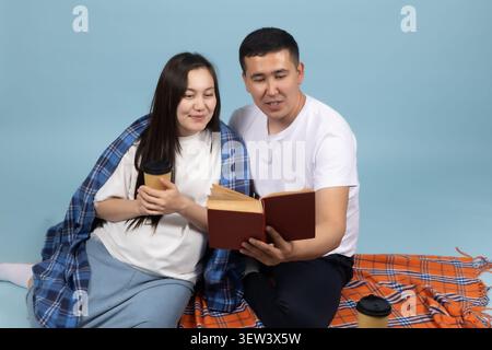 Happy young couple reading an interesting book together at home picnic Stock Photo