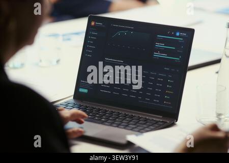Close up of business team reviewing oil field performance dashboard on laptop during meeting, analyzing production metrics and strategy. Ideal for energy management or corporate reporting Stock Photo