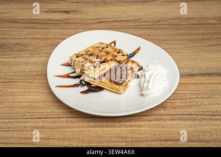Study of shapes and sizes on a tray with round, square, and heart-shaped waffles, evaluating the uniformity of browning Stock Photo