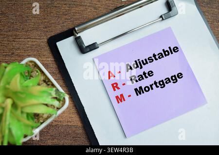 Concept of ARM - Adjustable Rate Mortgage write on sticky notes isolated on Wooden Table. Stock Photo