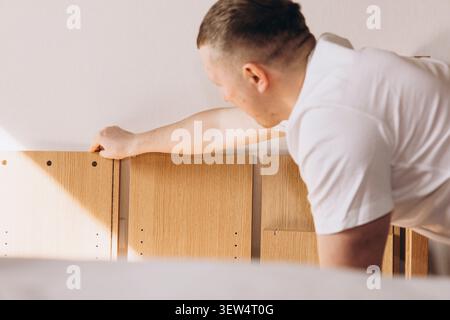 Man assembling flat pack furniture at home Stock Photo