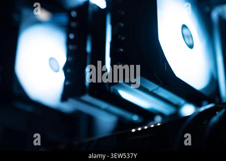 Detail of professional gaming PC interior. Motherboard, CPU tower cooler, graphics card, and RAM with colorful RGB LED lights. Stock Photo