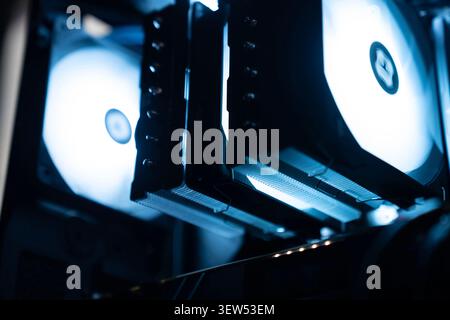 Detail of professional gaming PC interior. Motherboard, CPU tower cooler, graphics card, and RAM with colorful RGB LED lights. Stock Photo