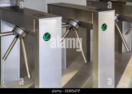 RFID card access control on modern stainless steel turnstile gate in smart office. Contactless security entrance and workplace access. Stock Photo