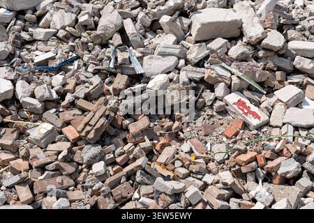 pile of rubble containing broken red bricks and fragmented concrete blocks from a destroyed building Stock Photo