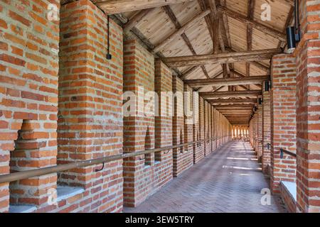 Long perspective view inside covered red brick defensive gallery of historic Smolensk fortress wall, Russia. Ancient medieval fortification architectu Stock Photo